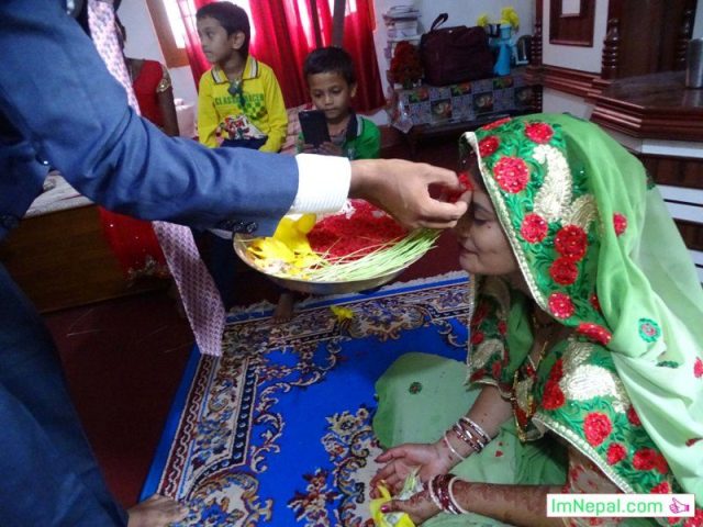 Dashain Tika Photos - Nepali Greatest festival Vijayadashami Picture - A Husband is putting Tika on His Wife forehead